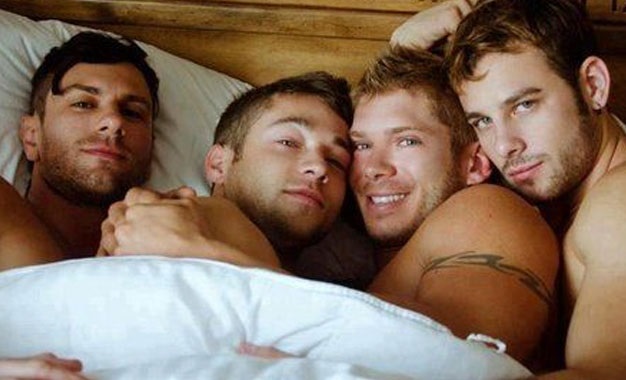 Group of hot gay swinger guys, all in bed together cuddling one another naked.